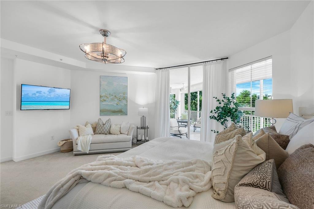 Bedroom with access to outside, carpet floors, and a chandelier