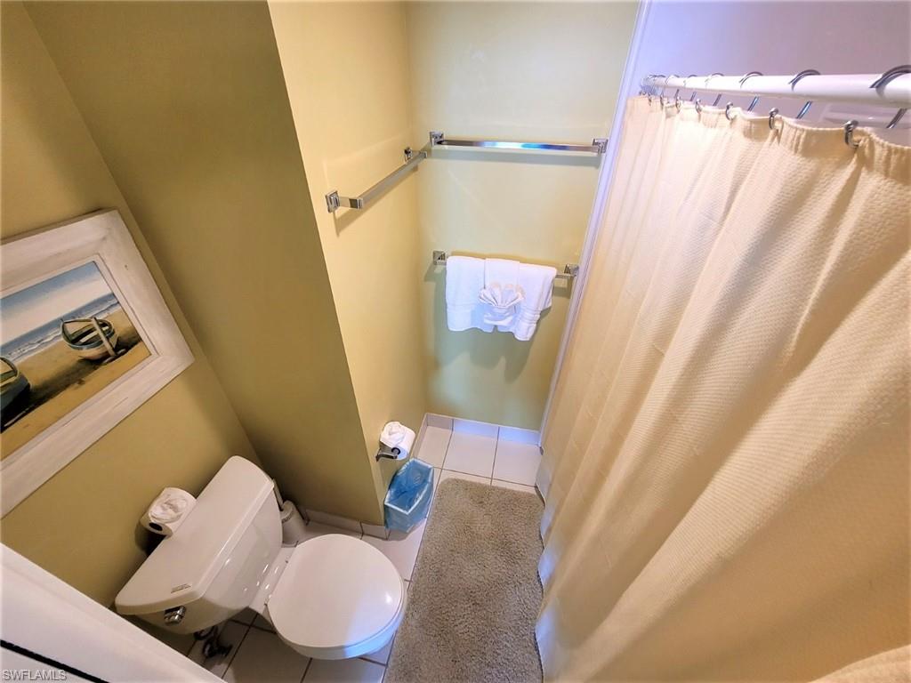 Full bath with light tile patterned floors and a shower with shower curtain