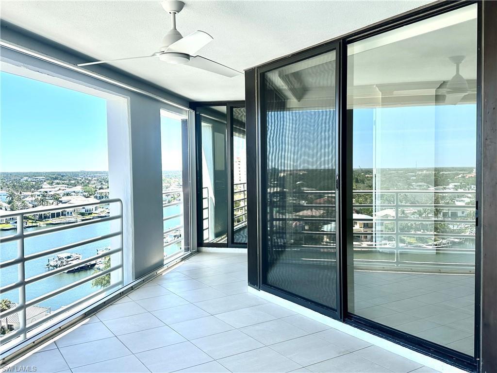 Balcony featuring a water view and ceiling fan