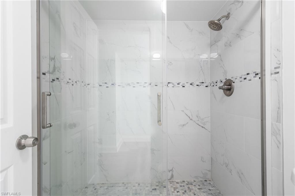 Full bath with a marble finish shower