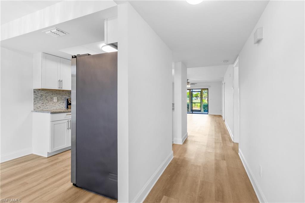 Corridor featuring light wood finished floors and baseboards