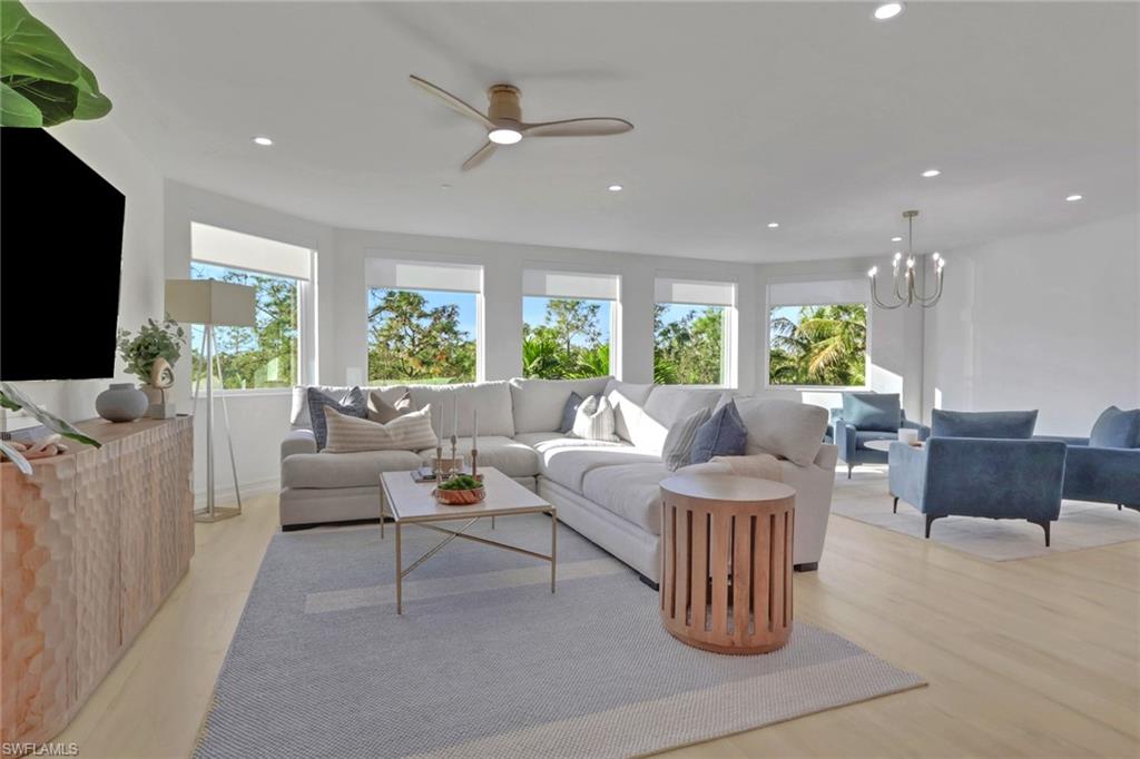 Living area featuring recessed lighting, light wood finished floors, ceiling fan, and a chandelier