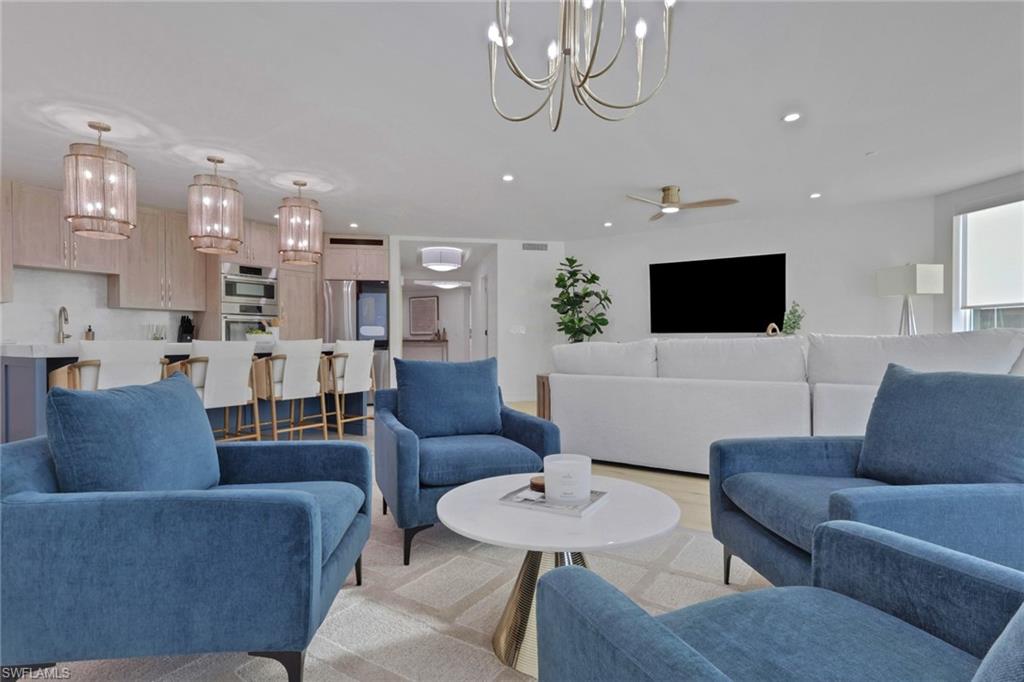Living room with a chandelier, wood finished floors, recessed lighting, and ceiling fan