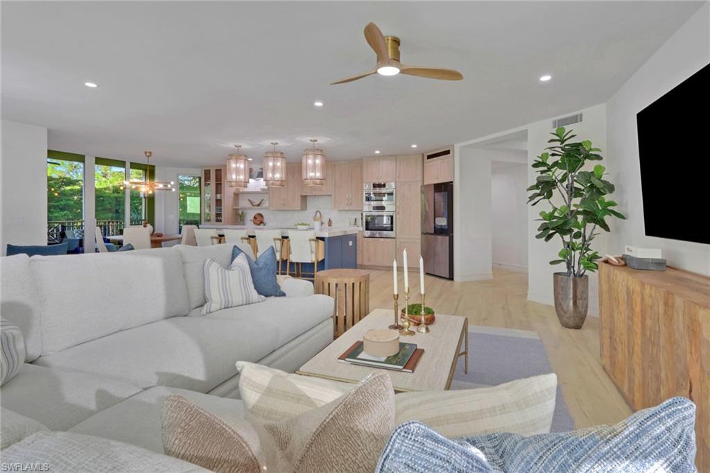 Living room featuring recessed lighting, light wood-type flooring, a chandelier, and ceiling fan