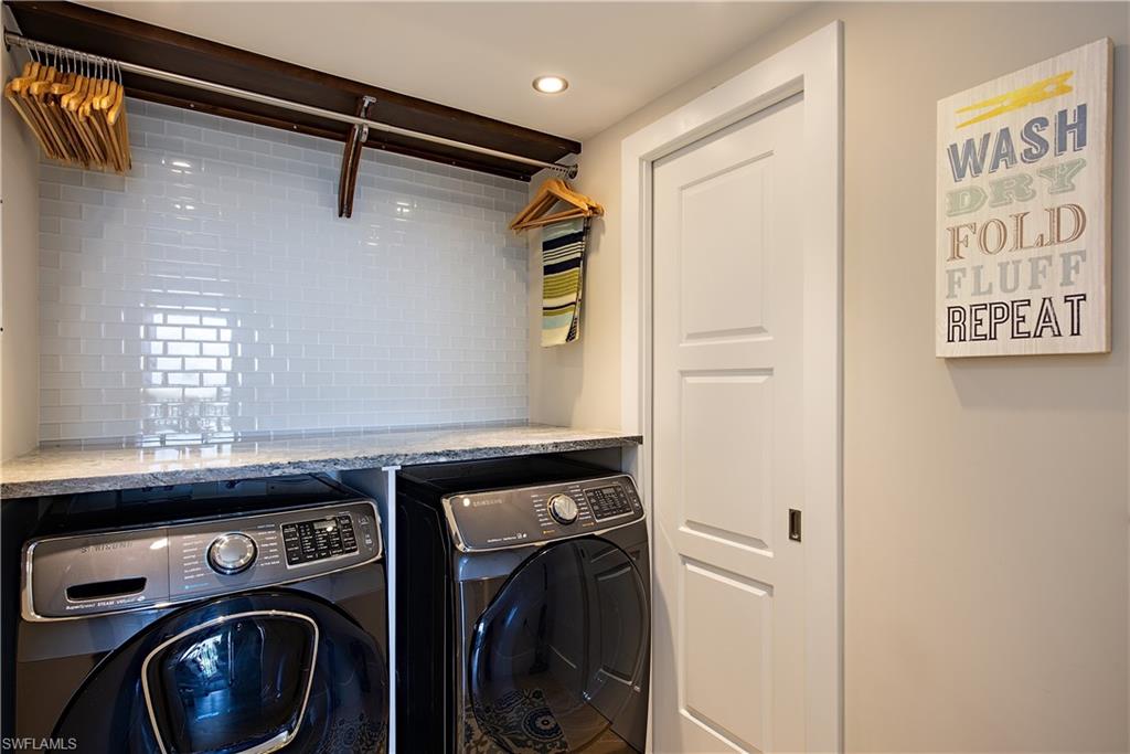 Laundry room featuring independent front-loading washer and dryer and recessed lighting