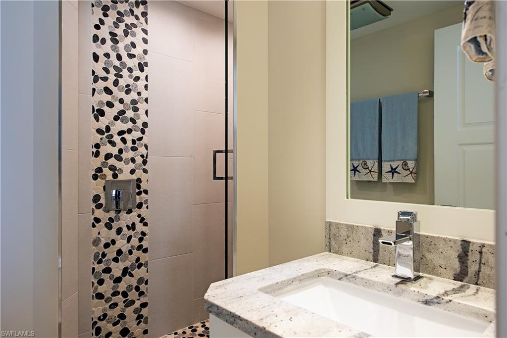 Full bathroom for the two guest bedrooms featuring a shower stall and vanity