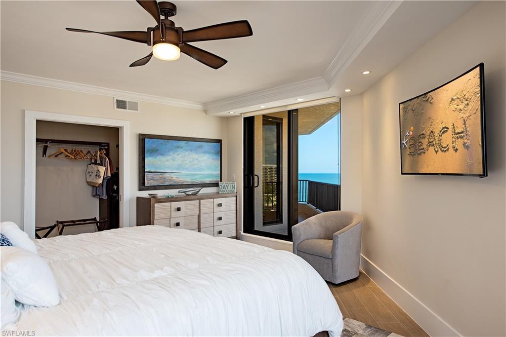 Primary Bedroom featuring King size mattress, walk-in closet, and crown molding.  Access to exterior, recessed lighting, wood finish floors, and ceiling fan