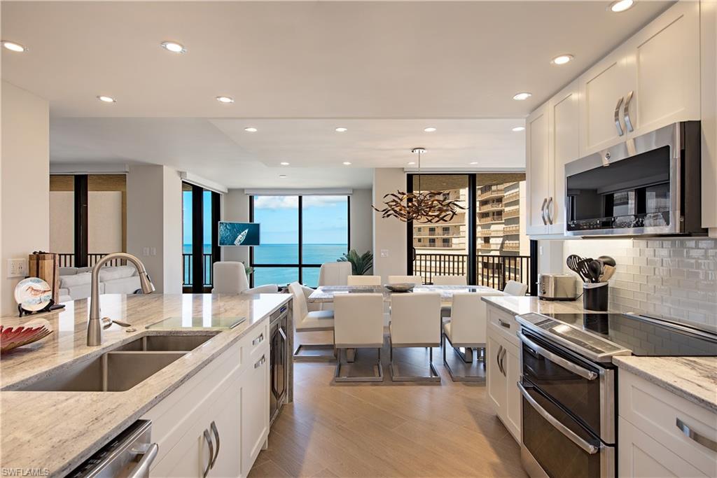 Kitchen with stainless steel appliances, recessed lighting, a chandelier, decorative backsplash, and light wood-style floors