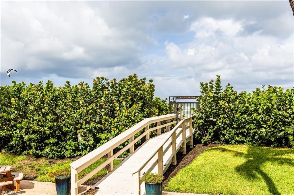 View of grassy area with bridge walkway taking you to the sugar white sandy BEACH.