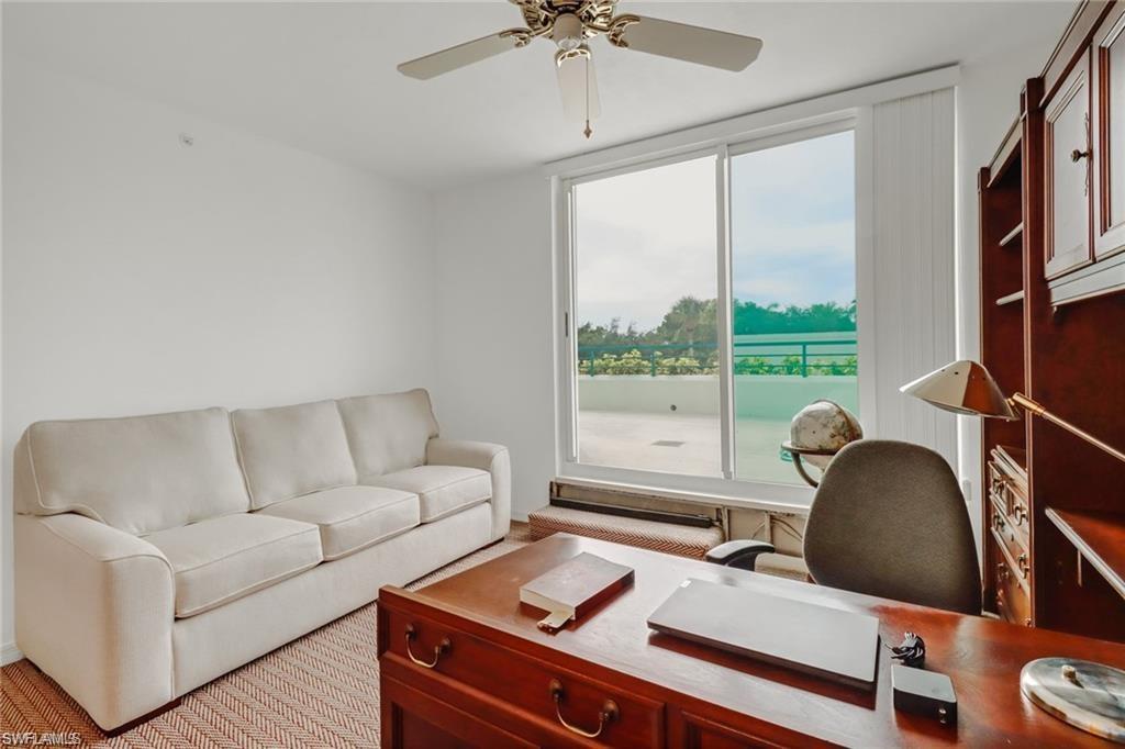 Office area with ceiling fan and light colored carpet. Sofa bed