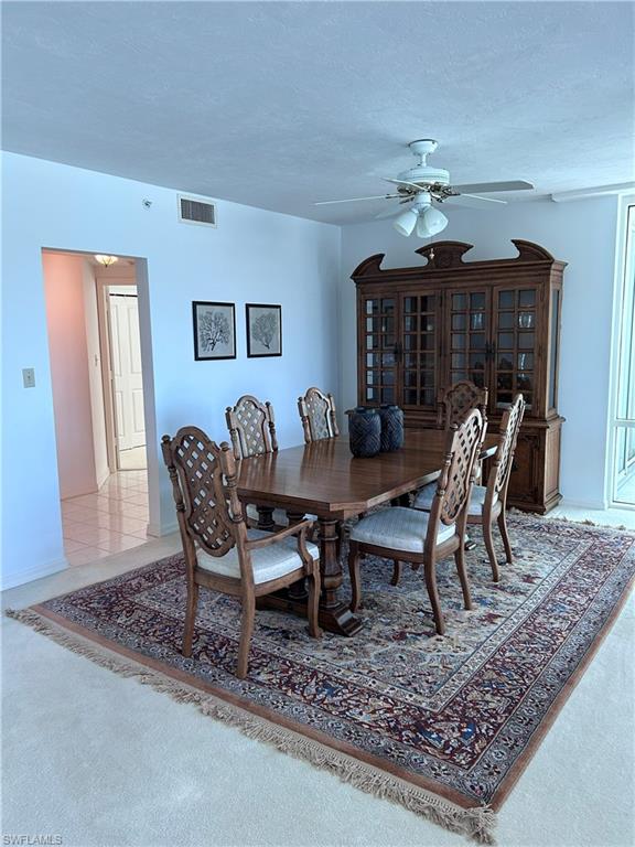 Dining space featuring carpet floors, a textured ceiling, and a ceiling fan