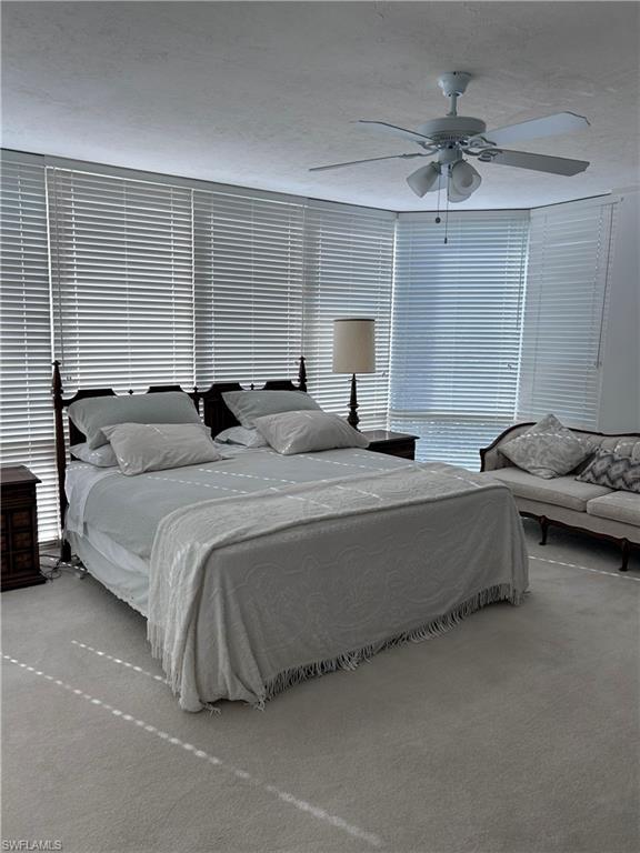 Bedroom featuring carpet floors, ceiling fan, and a textured ceiling