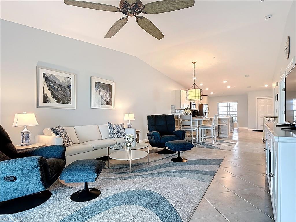 Living area with light tile patterned floors, a ceiling fan, recessed lighting, and lofted ceiling