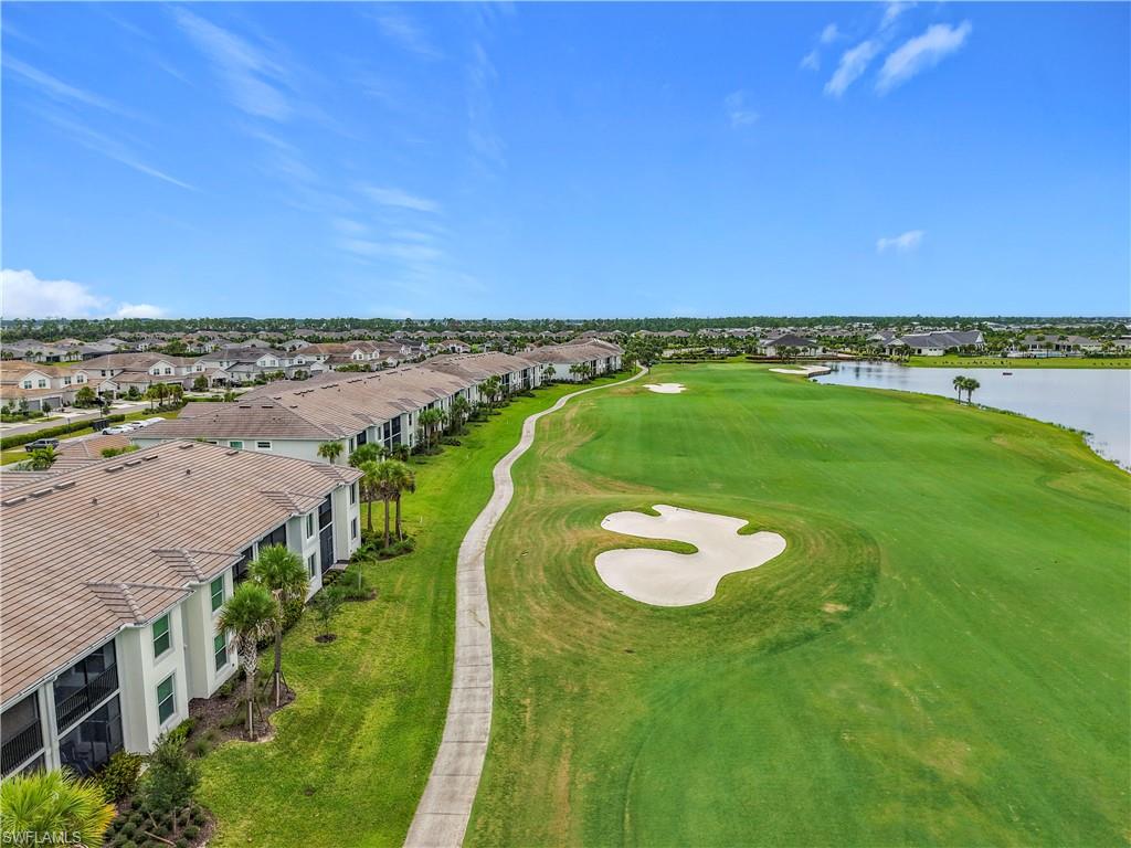 Aerial perspective of suburban area featuring a local golf course and a large body of water
