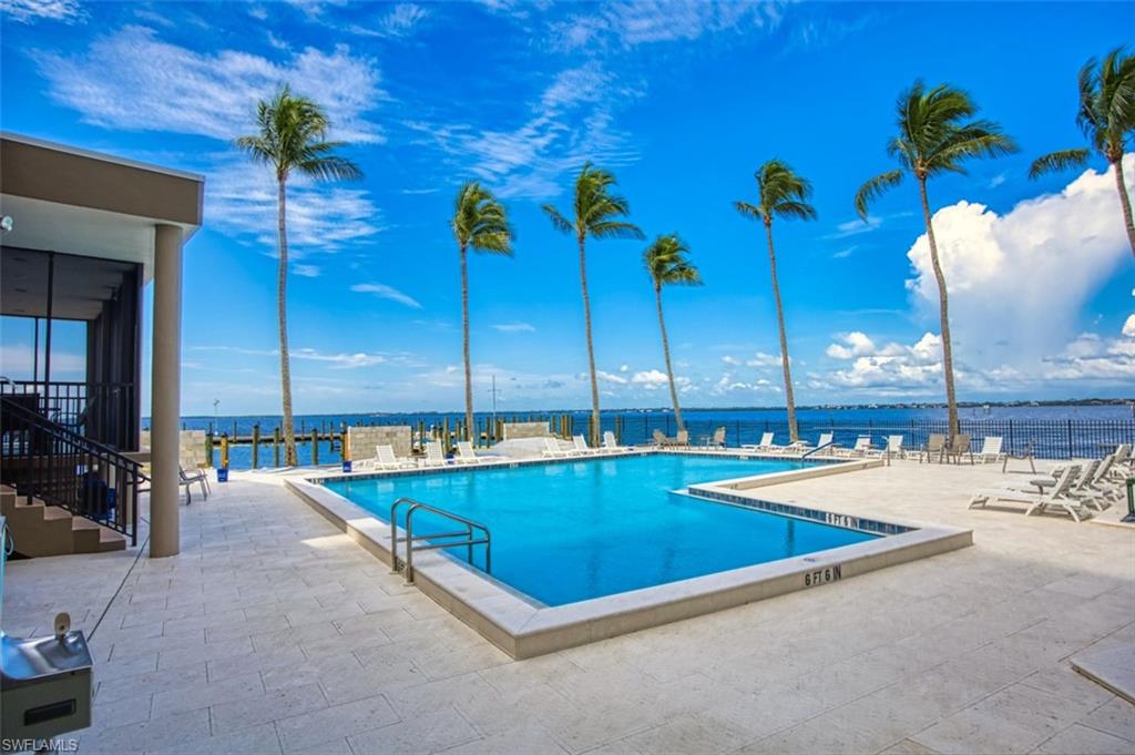 Community pool with a water view and a patio area