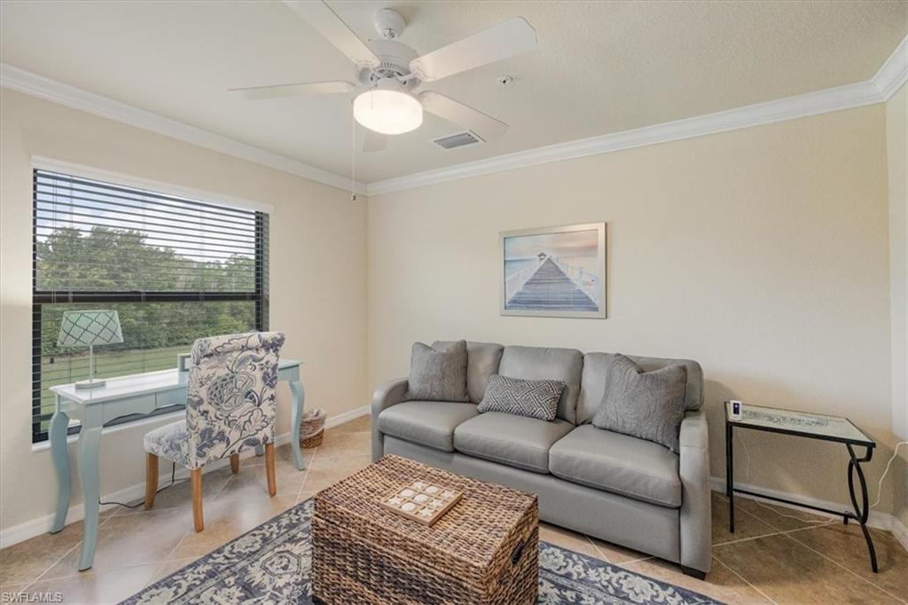 Living room featuring crown molding, ceiling fan, and tile patterned floors