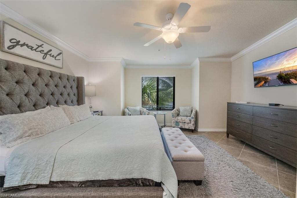Bedroom featuring light tile patterned floors, ornamental molding, and ceiling fan