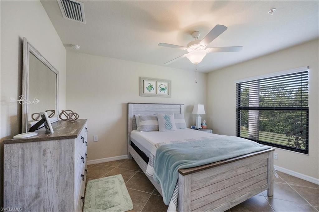 Tiled bedroom featuring ceiling fan
