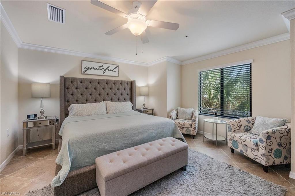 Tiled bedroom featuring ceiling fan and crown molding