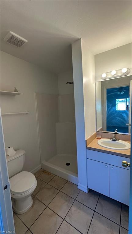 Bathroom featuring vanity, a shower stall, and light tile patterned flooring