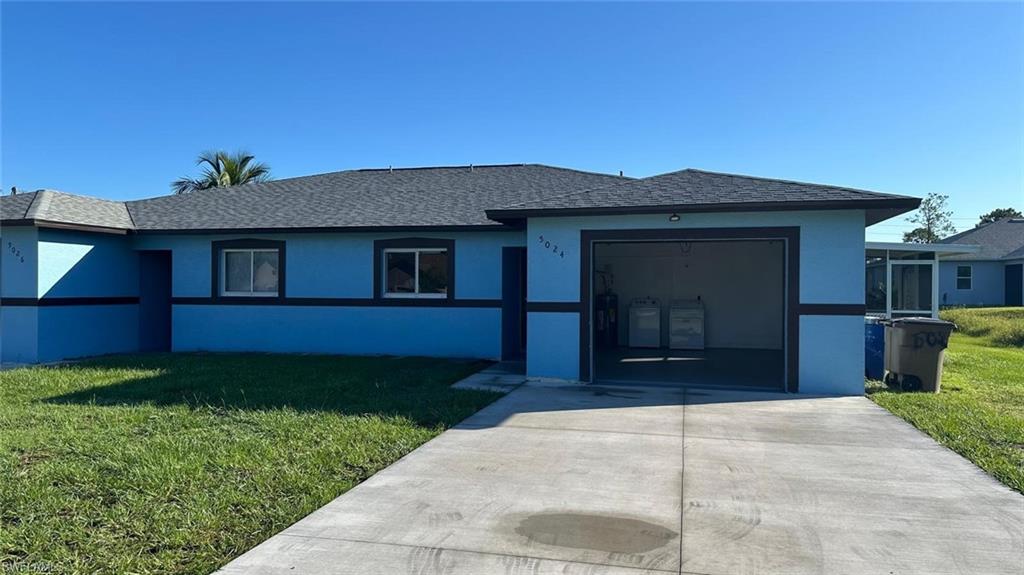 Ranch-style home with a front lawn, stucco siding, a shingled roof, and concrete driveway