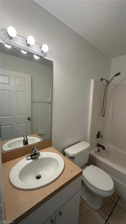 Full bath with  shower combination, vanity, and light tile patterned floors