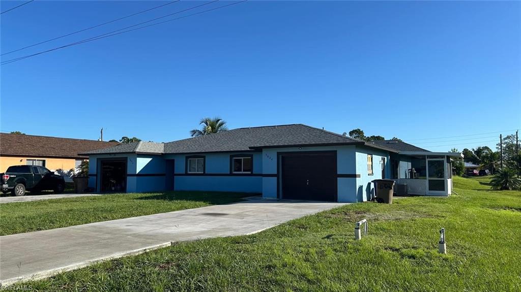 Ranch-style house featuring stucco siding, concrete driveway, an attached garage, a front yard, and a shingled roof