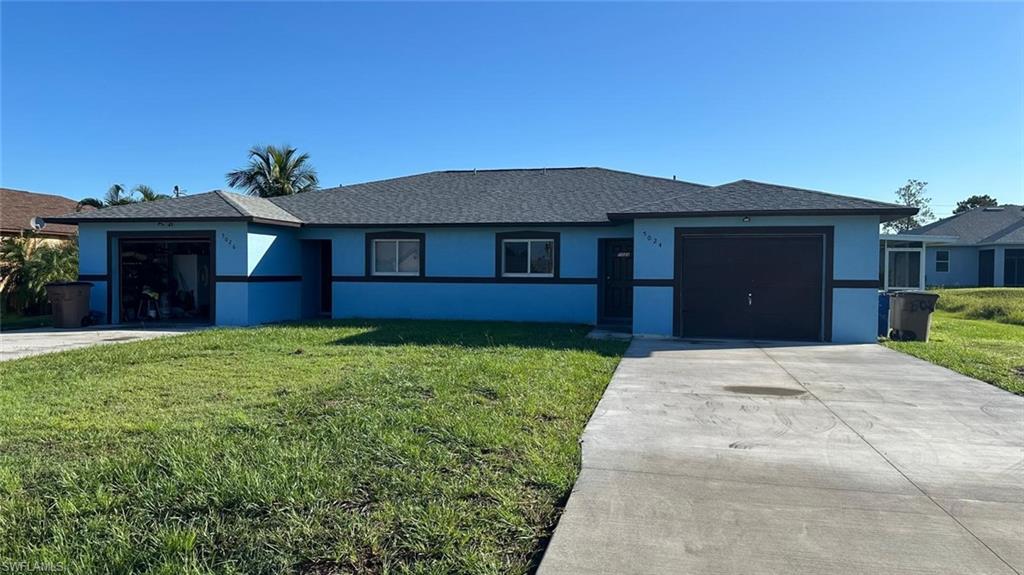 View of front of property with an attached garage, concrete driveway, stucco siding, and a front lawn