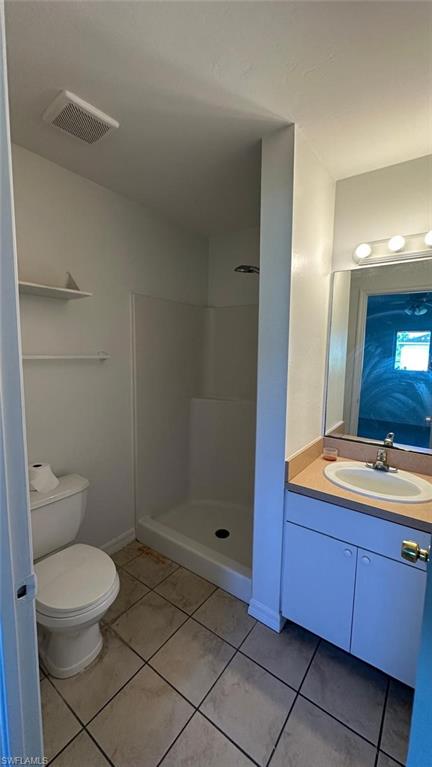 Bathroom featuring vanity, a shower stall, and light tile patterned flooring