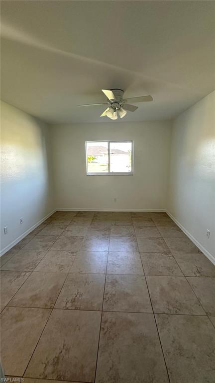 Unfurnished room featuring a ceiling fan and light tile patterned floors
