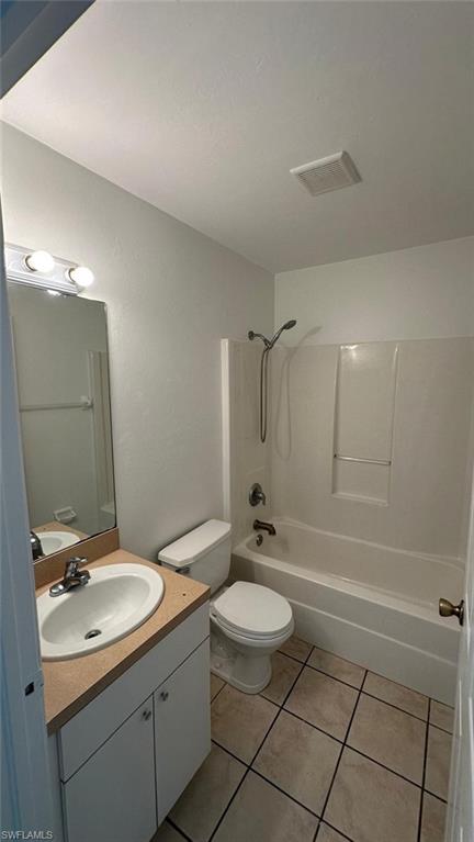 Full bath with tub / shower combination, vanity, and light tile patterned floors