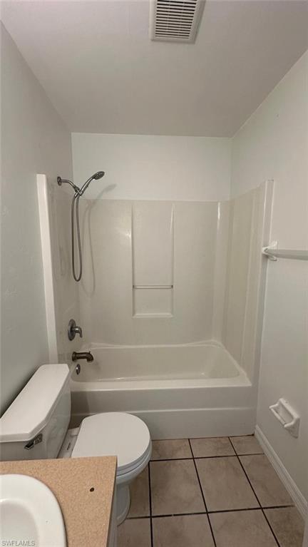 Bathroom featuring bathing tub / shower combination, light tile patterned floors, and vanity