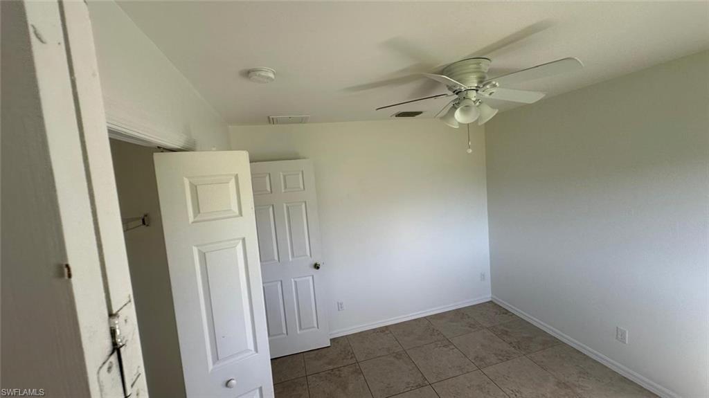 Spare room featuring a ceiling fan and light tile patterned floors