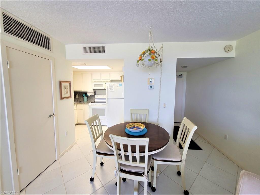 Dining room featuring light tile patterned flooring and a textured ceiling
