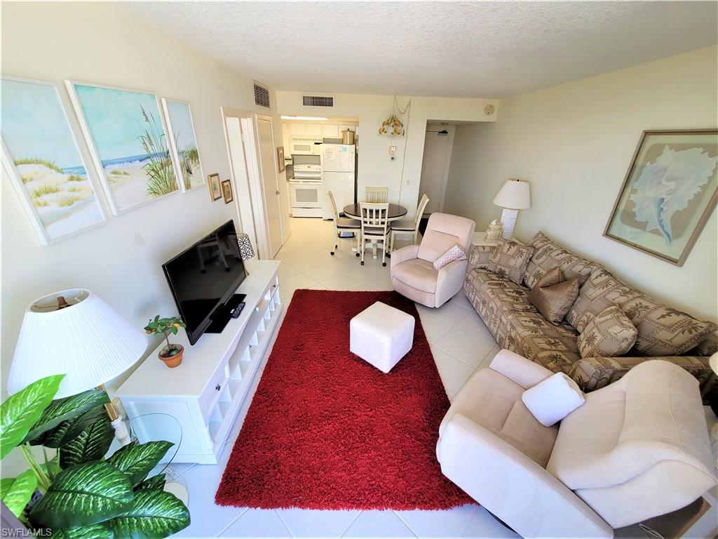 Living room featuring light tile patterned floors and a textured ceiling