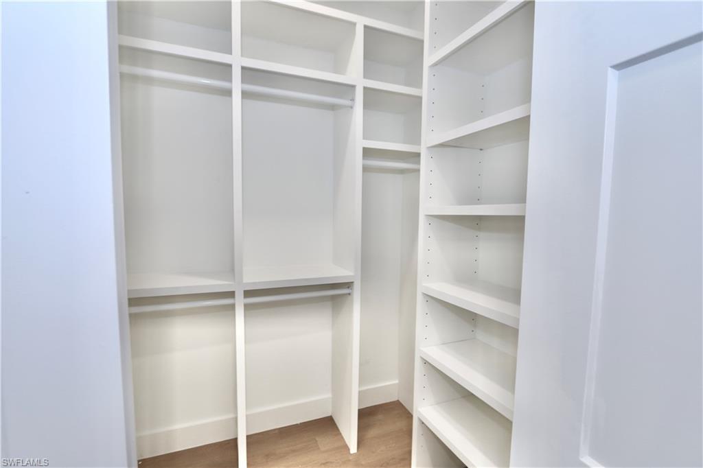 One of two primary bedroom walk in closets with custom wood closet organizer system