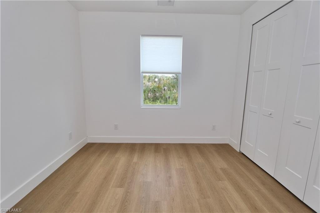 Unfurnished bedroom featuring a closet and light wood-style floors