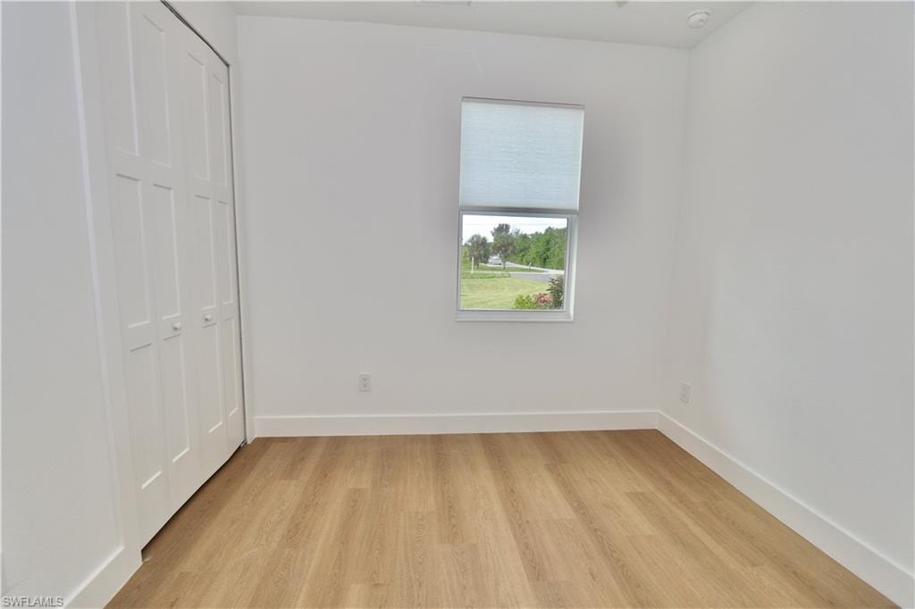 Unfurnished bedroom featuring a closet and light wood-style floors