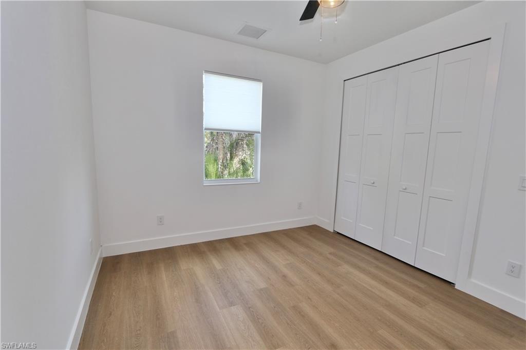 Unfurnished bedroom featuring light wood finished floors, a ceiling fan, and a closet