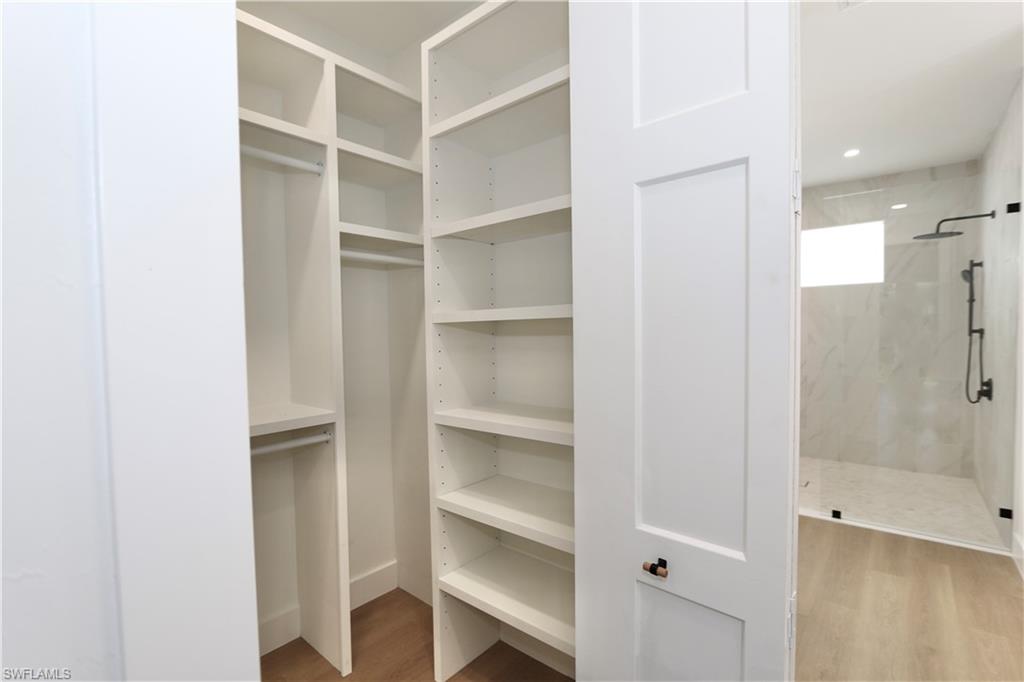 One of two primary bedroom walk in closets with custom wood closet organizer system