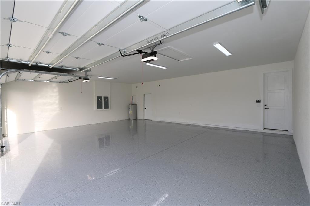 3 car oversized Garage with water heater, a garage door opener, and electric panel