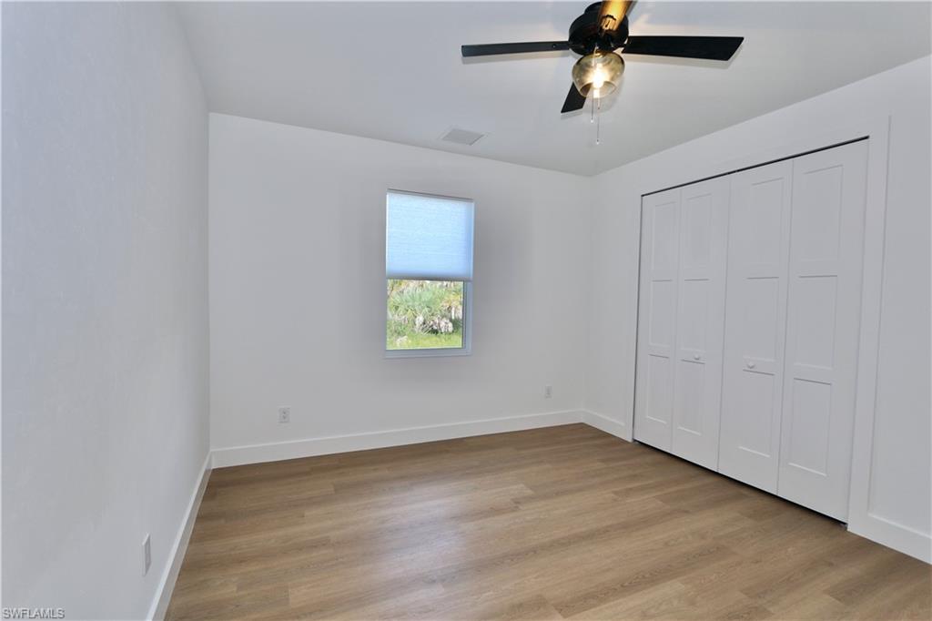 Unfurnished bedroom featuring light wood-style flooring, ceiling fan, and a closet
