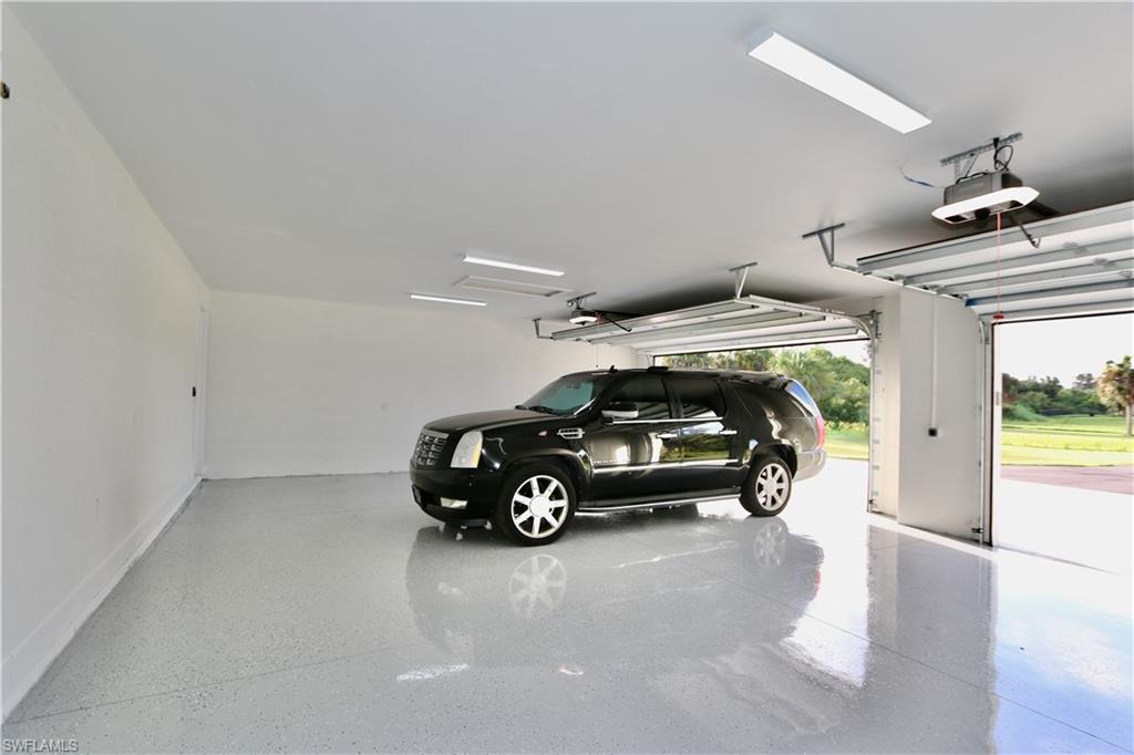 3 car oversized Garage Showing extra space with a full sized SUV parked in it.