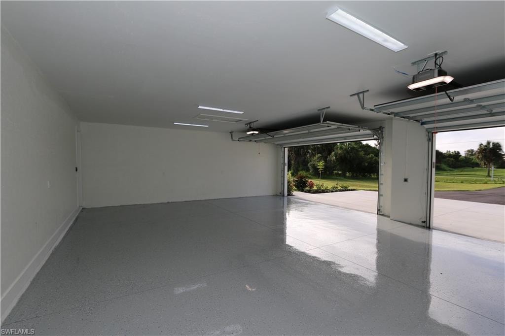 3 car oversized Garage featuring a garage door opener
