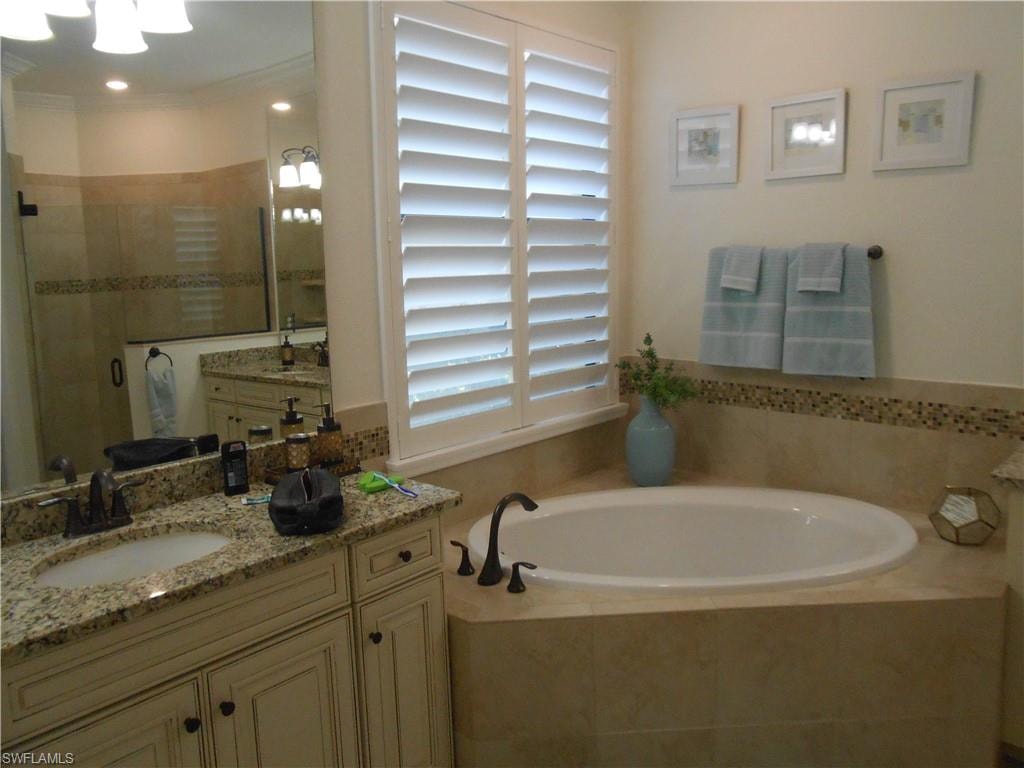 Full bath featuring vanity, a stall shower, and a bath