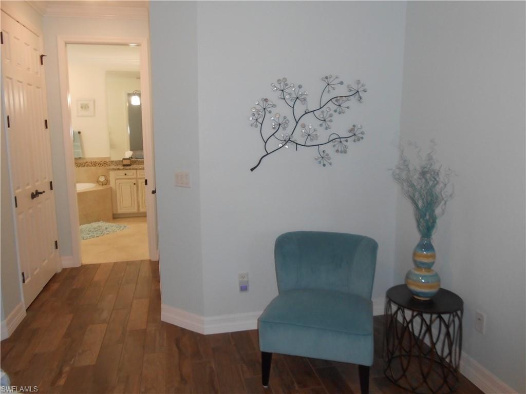 Sitting room featuring dark wood-type flooring and baseboards