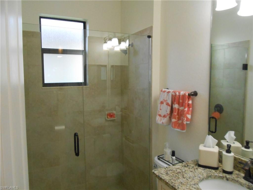 Full bathroom featuring a stall shower and vanity