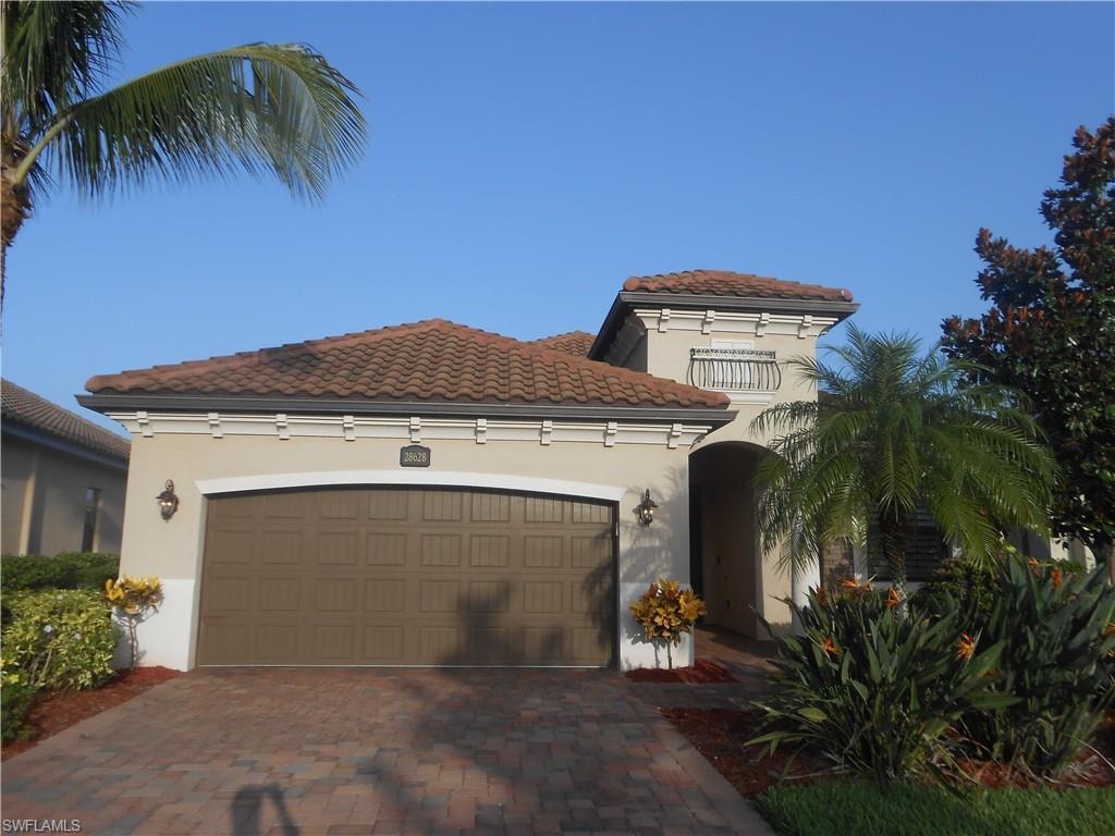Mediterranean / spanish-style house featuring a garage, stucco siding, decorative driveway, and a tile roof
