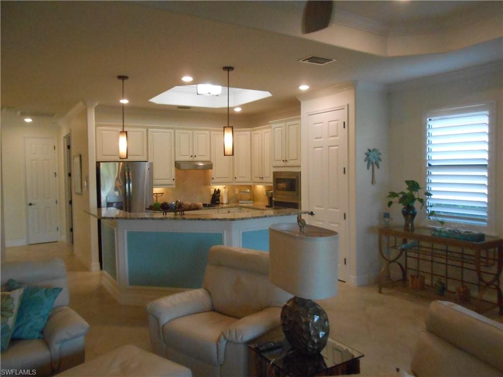 Living area with recessed lighting, crown molding, and a skylight
