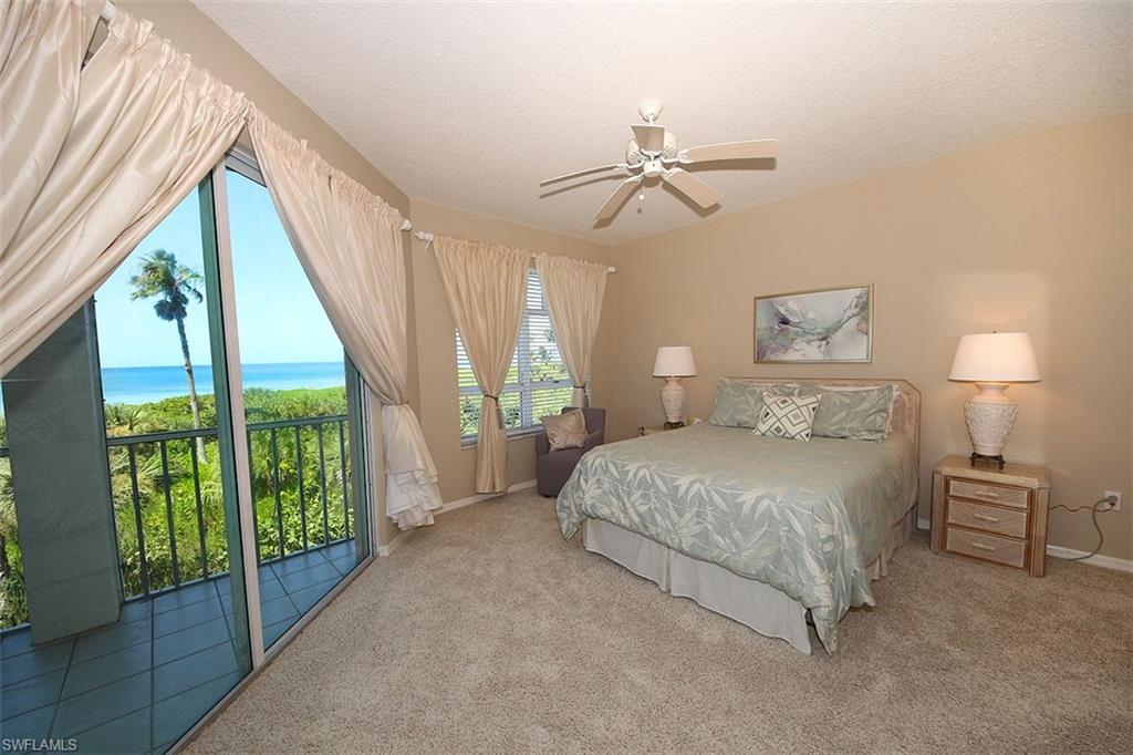 Carpeted bedroom featuring access to exterior, a textured ceiling, ceiling fan, and a water view